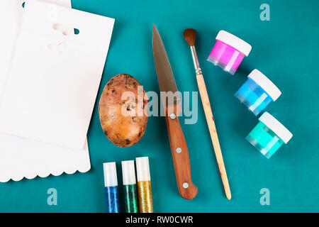 Diy Ostereier aus Pappe und Kartoffel Stempel, Ostern Grußkarte auf grünem Hintergrund. Geschenk Idee, Dekor Frühling, Ostern. Schritt für Schritt. Ansicht von oben. Stockfoto