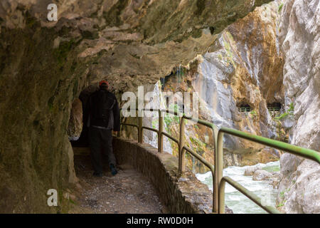 Wanderweg (Cares Trail oder Ruta del Cares) in den engen Tunnel entlang des Flusses Cares in trüben Frühling (in der Nähe von Kain), Picos de Europa National Park, Stockfoto
