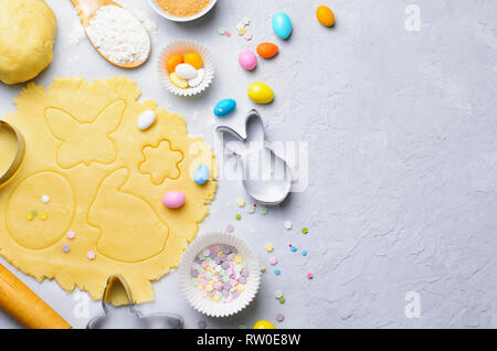 Herstellung von Ostern Cookies, Teig, Ausstechformen, Zucker besprüht, festliche Ostern Backen Hintergrund Stockfoto