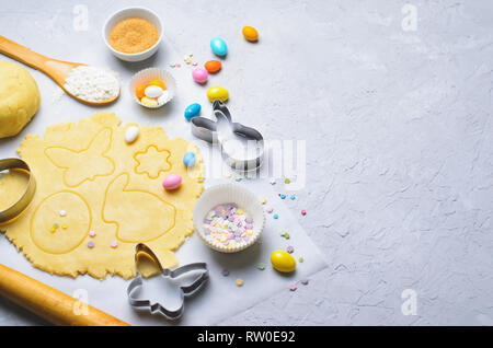 Herstellung von Ostern Cookies, Teig, Ausstechformen, Zucker besprüht, festliche Ostern Backen Hintergrund Stockfoto