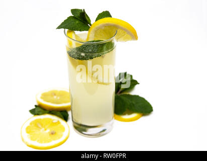 Ein Glas frische Limonade, vor dem Hintergrund von Zitrone und Minze, auf einem weißen Hintergrund. Stockfoto