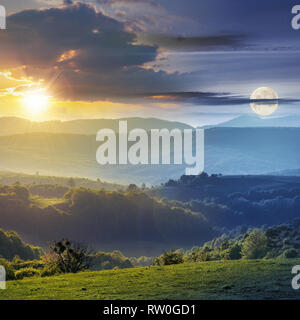 Tag und Nacht Zeit ändern Konzept über Rumänien Landschaft mit grünen Hügeln unter einem Mond und Sonne. Landwirtschaftliche Wiese. Bergrücken Stockfoto