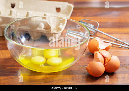 Gebrochene rohe Eier in eine Glasschüssel und Shell nächste Stockfoto