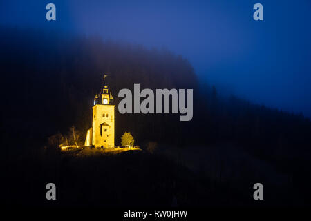 Blick von der kleinen Stadt Bergbau Erzberg zu Gelb shift tower Schichtturm auf einem nebligen Abend im Winter in der Steiermark, Österreich aufhellen Stockfoto