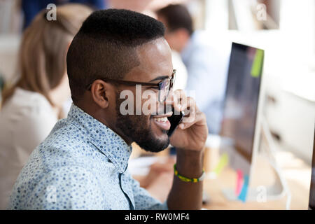 Lächelnd afrikanischen Mitarbeiter am Telefon sprechen mit Client Stockfoto