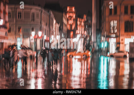 Stadt Straße in regnerischen Abend, abstrakten Hintergrund des unscharfen Menschen Zahlenangaben unter Regenschirmen, orange Tönen. Vorsätzliche Bewegungsunschärfe. Jahreszeiten, Wetter Stockfoto