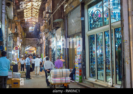 Teheran, Iran - 22. MAI 2017: Besetzt Grand Bazaar Street mit Reihen von Zählern und Schuhe shop Windows, Mann, mit Warenkorb Stockfoto