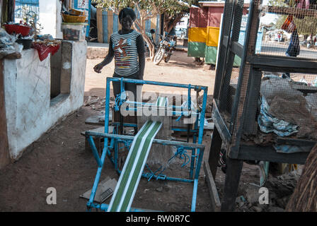 Ein Foto von einem lokalen ghanaischen Geschäftsfrau, die eine blaue Webmaschine auf einer Straße von Bolgatanga. Stockfoto