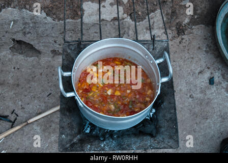 Ein Foto von einem Topf voll lecker würzigen lokale Suppe kochen auf dem Feuer in ländlichen ghanaischen Dorf Kongo. Stockfoto