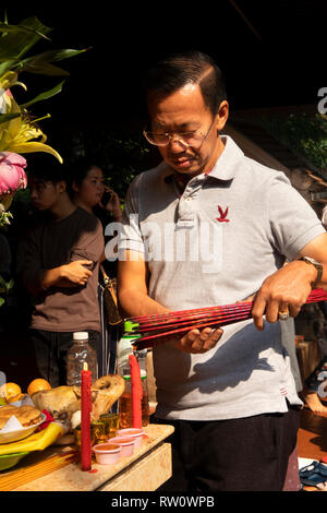 Kambodscha, Phnom Penh, Stadtzentrum, Wat Phnom, Neak Ta Preah Chao Schrein, verehrer Beleuchtung Bündel Räucherstäbchen Stockfoto
