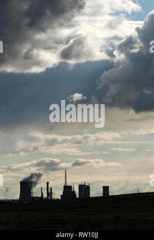 Industrielle Silhouette auf Teeside mit einem dramatischen Himmel, während die Sonne durch eine Wolkenlücke scheint Stockfoto