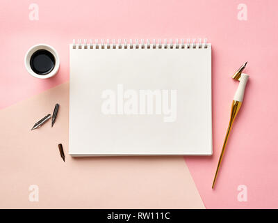 Mock up von leeren artist Skizzenbuch auf rosa Hintergrund mit Kalligraphie Feder und Tinte. Die Aussicht von oben. Stockfoto