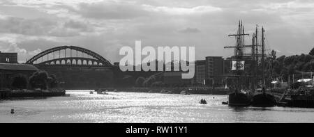 Monochromes Bild von hohen Schiffen in Port of Sunderland in Nord-Ost-England mit Wearmouth-Brücke nach links und Segelschiffen nach rechts Stockfoto