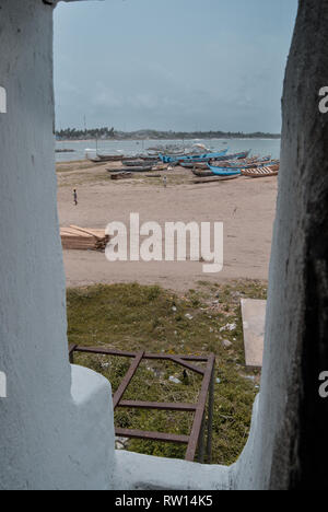 Blick auf die Landschaft (Sandstrand und alte hölzerne Boote) in der Umgebung des alten Elmina slave Schloss in Elmina, Ghana, Westafrika Stockfoto