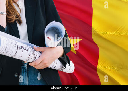 Kameruner Architekt Frau mit Blueprint gegen Kamerun wehende Flagge Hintergrund. Bau und Architektur Konzept. Stockfoto