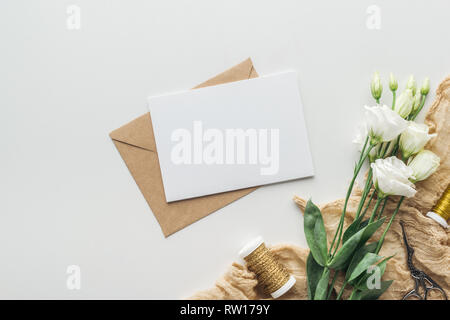 Blick von oben auf die eustoma, Umschläge mit leeren, Spulen von Faden und Stoff auf grauem Hintergrund Stockfoto