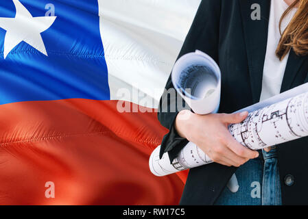 Chilenischen Architekten Frau mit Blueprint gegen Chile wehende Flagge Hintergrund. Bau und Architektur Konzept. Stockfoto