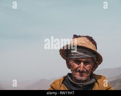 ATLAS, MAROKKO - 28. März 2018: Portrait eines alten Mannes im Atlasgebirge Kräuter verkaufen, schauen in die Kamera Stockfoto