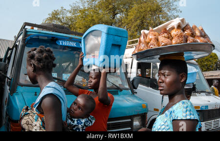 Besetzt die lokalen ghanaischen Anbieter am Markt ankommen. Produkte sind von Frauen auf dem Kopf durchgeführt Stockfoto