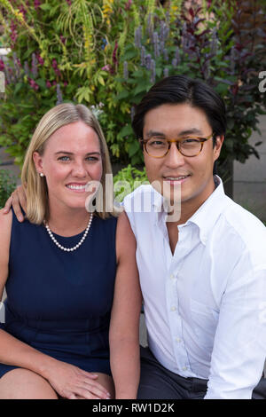 Attraktive Mixed Race Paar Stellen im Garten, USA Stockfoto