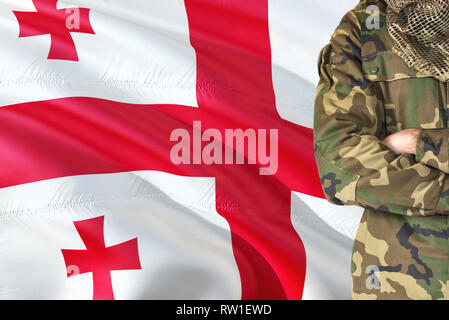 Gekreuzte Arme georgische Soldaten mit nationalen wehende Flagge auf Hintergrund - Georgien militärischen Thema. Stockfoto