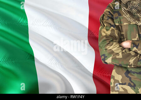 Gekreuzte Arme italienische Soldaten mit nationalen wehende Flagge auf Hintergrund - Italien militärischen Thema. Stockfoto