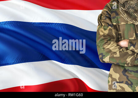 Gekreuzte Arme Thai Soldat mit nationalen wehende Flagge auf Hintergrund - Thailand militärische Thema. Stockfoto