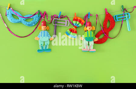 Purim feier Konzept (jüdischer Karneval Urlaub), Clowns, Masken und Krachmacher über Holz- grüner Hintergrund Stockfoto