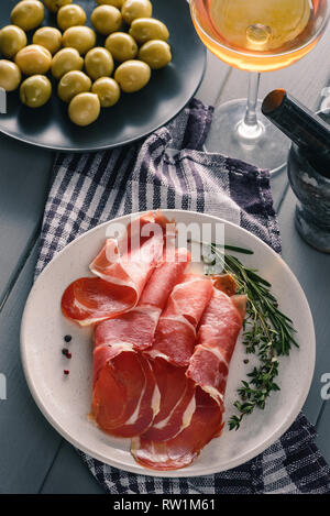 Jamon platter mit Kräutern Stockfoto