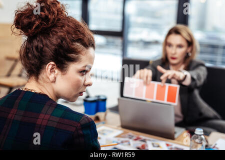 Curly assistant Gefühl unangenehm mit strengen Chefin Stockfoto