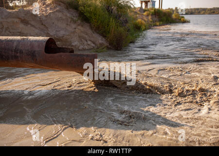 Verschmutzung der Umwelt durch Abfälle aus Rohren oder Drainage. Das Konzept der Natur Umweltverschmutzung Kanalisation. Entlastung von toxischen oder verunreinigtes Wasser in Stockfoto