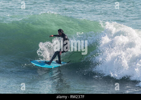 Fowey, Cornwall, UK. 4 Mär, 2019. UK Wetter. Ein Surfer die Dünung von Sturm Freya heute Links. Wind und Wellen haben im Vergleich zu gestern gefallen. Foto: Simon Maycock/Alamy leben Nachrichten Stockfoto