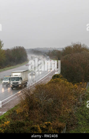 Moira, Nordirland. 04. März 2019. UK Wetter - nasse und kalte Frühling Tag mit starken Regen, Schneeregen und Schnee und Wasser Duschen, die alle in der Mischung. Verkehr auf der Autobahn mit Licht am nassen Wetter auf der M1. Quelle: David Hunter/Alamy Leben Nachrichten. Stockfoto