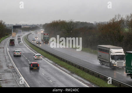 Moira, Nordirland. 04. März 2019. UK Wetter - nasse und kalte Frühling Tag mit starken Regen, Schneeregen und Schnee und Wasser Duschen, die alle in der Mischung. Verkehr auf der Autobahn im Regen auf der M1. Quelle: David Hunter/Alamy Leben Nachrichten. Stockfoto