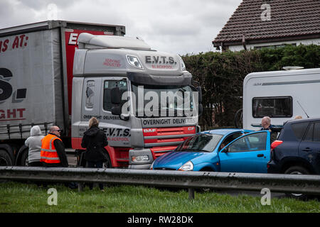 LKW-Verkehrsunfall mit Auto auf zweispuriger Fahrbahn; TRC auf dem A565 Gravel Lane Kreisverkehr zwischen DAF-Schwerlastwagen und kleinem Ford-Kompaktwagen, der am Ende seitwärts die Straße hinunter geschoben wurde. Stockfoto