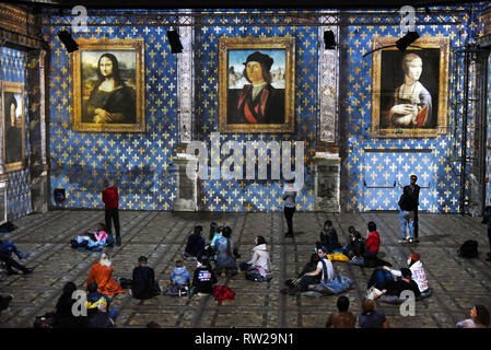 03. März 2019, Sachsen, Leipzig: Während die Multimedia Show "LEONARDO DA VINCI, Raffael, Michelangelo, Riesen der Renaissance' in der Kunstkraftwerk, die Besucher werden Die da Vinci Gemälde "Mona Lisa", "Porträt eines jungen Mannes" und "Dame mit dem Hermelin" (L-R), die auf den Mauern der ehemaligen Maschinenhalle, die bis zu acht Meter hohen projiziert werden. Die außergewöhnliche Multimedia Projektion der italienischen Immersive Kunst Fabrik, die anlässlich des 500. Geburtstags von Leonardo da Vincis Tod gezeigt werden wird, wurde bereits von über 8000 Besucher seit der Eröffnung auf gesehen worden Stockfoto