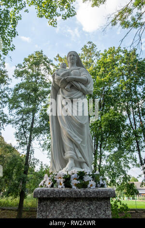 Steinerne Statue in Holz- Bereich gefunden, die das Abbild der Jungfrau Maria mit dem Jesuskind in ihren Armen, Sieradz, Woiwodschaft Łódź, Polen Stockfoto