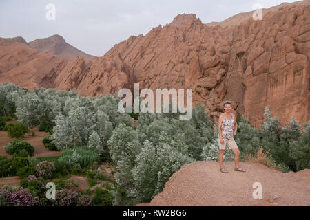 Eine weibliche Touristische posiert für ein Foto vor dem Atlas Gebirge, Ouzazate, Dades-schlucht Stockfoto