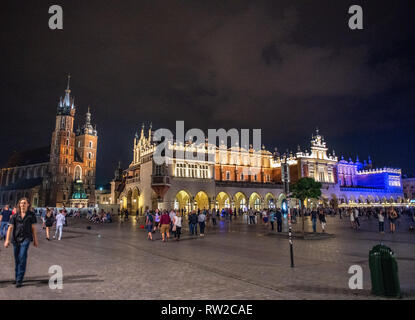 Menschen zu Fuß rund um den Hauptmarkt von Krakau - w Altstadt bei Nacht so hell leuchtet das Äußere der Kirche Unserer Lieben Frau in den Himmel (S Stockfoto