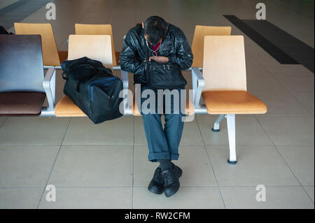 01.03.2019, Singapur, Republik Singapur, Asien - ein Fahrgast Schlafen neben seinem Handgepäck in einem öffentlichen Bereich auf der Flughafen Singapur Changi. Stockfoto