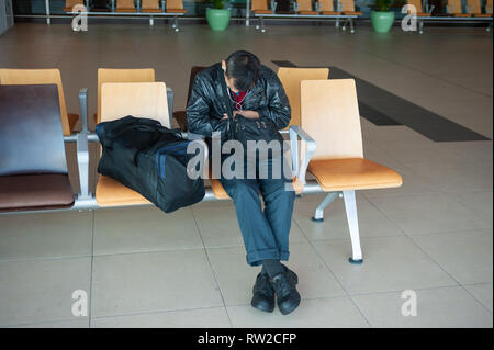 01.03.2019, Singapur, Republik Singapur, Asien - ein Fahrgast Schlafen neben seinem Handgepäck in einem öffentlichen Bereich auf der Flughafen Singapur Changi. Stockfoto