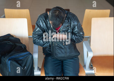 01.03.2019, Singapur, Republik Singapur, Asien - ein Fahrgast Schlafen neben seinem Handgepäck in einem öffentlichen Bereich auf der Flughafen Singapur Changi. Stockfoto