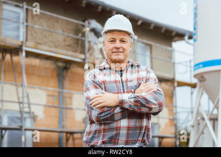 Stolz Gipser stand vor der Gerüst auf der Baustelle Stockfoto