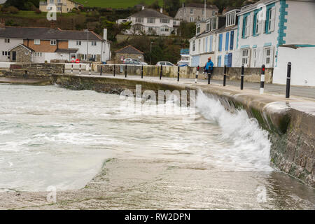 Editorial: Menschen & Logos. , Portmellon Mevagissey, Cornwall, UK. 03.03.2019. Großen swells trat herauf durch Sturm Freya Crash gegen das Meer die Abwehrkräfte. Stockfoto