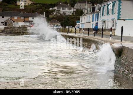 Editorial: Menschen & Logos. , Portmellon Mevagissey, Cornwall, UK. 03.03.2019. Großen swells trat herauf durch Sturm Freya Crash gegen das Meer die Abwehrkräfte. Stockfoto