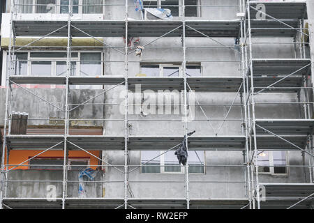 Gerüste an der Fassade eines Mehrfamilienhauses für die Arbeiter, das Gebäude zu isolieren, während Winte Stockfoto