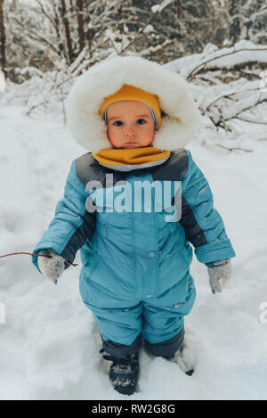 Ein Kind für einen Spaziergang im Winter. Kind im Winter Kleidung. Familie Spaziergänge in der Natur im Winter. Familie gehen. Winter Forest. Snow park. Stockfoto