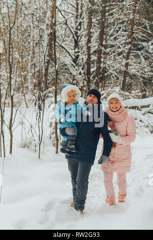 Wandern Familie mit einem Kind. Familie Spaziergänge in der Natur im Winter. Familie Winter Spaziergang in der Natur. Viel Schnee. Verschneiten Wald. Stockfoto