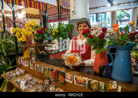 Verkäuferin mit Blumen in der Markthalle Mercado dos Lavradores in Funchal, Madeira, Portugal, Europa | Vertrieb Frau mit Blumen an die Halle Stockfoto