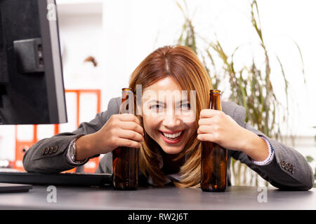 Betrunken business Frau trinkt Bier in einem Büro Stockfoto